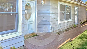 Panorama frame Facade of home with red brick pathway leading to the doors and arched gate