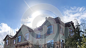 Panorama frame Facade of a home surrounded with lush trees and snowy ground in winter