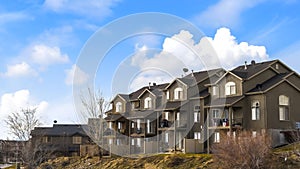 Panorama frame Houses with balconies and arched windows against blue sky with puffy clouds