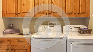 Panorama frame Laundry room interior with washer dryer and counter against the beige wall