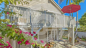 Panorama frame Patio with an eating area under the balcony with a red umbrella in the corner