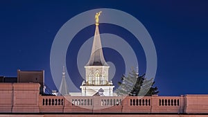 Panorama frame Provo City Center Temple with statue of angel and spire against blue evening sky