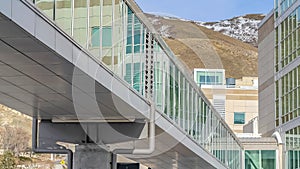 Panorama frame Skybridge connected to a modern building with mountain and blue sky background