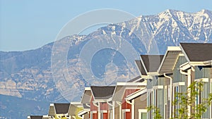 Panorama frame Snowy mountain and blue lake view behind townhouses with colorful exterior walls