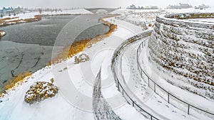 Panorama frame Spiralling path going up a bridge near an icy lake in Daybreak Utah