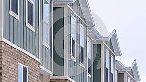 Panorama frame Vertical siding and stone brick wall at the townhomes upper storey against sky