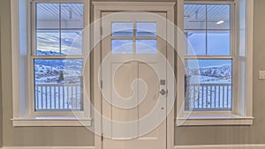 Panorama frame White front door flanked by windows interior