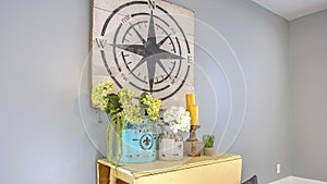 Panorama frame White table with ornaments and basket with pillows inside a room with wood floor