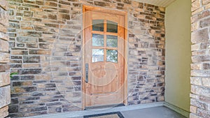 Panorama frame Wooden front door of modern house with stone walls