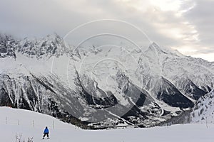 Panorama of French Alps with mountain ranges covered in snow and clouds in winter