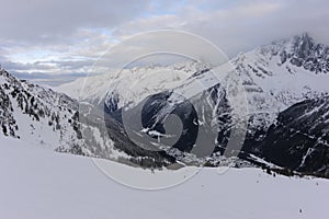 Panorama of French Alps with mountain ranges covered in snow and clouds in winter