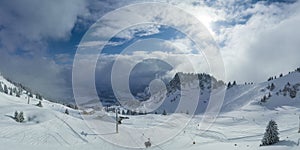 panorama of fresh snow in tyrolean ski resort with ski tracks sky