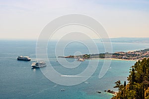 Panorama of Giardini Naxos bay and cruise ships anchored in Sicily, Italy. View from Taormina city