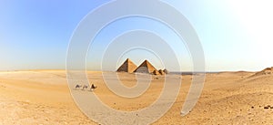 Panorama of the Giza desert with the Great Pyramids and camels, Egypt