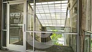 Panorama Glass door and wall with view of slanted frosted roof over stairway of building