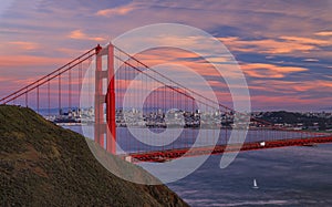 Panorama of the Golden Gate bridge with the Marin Headlands and San Francisco skyline at colorful sunset, California