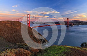 Panorama of the Golden Gate bridge with the Marin Headlands and San Francisco skyline at colorful sunset, California