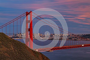 Panorama of the Golden Gate bridge with the Marin Headlands and San Francisco skyline at colorful sunset, California