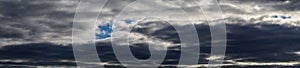 Panorama of gray storm clouds, heavy clouds with autumn rain in the dramatic sky are an omen of heavy rains photo