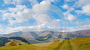 Panorama of green hills, trees and amazing clouds in Carpathian mountains in the autumn. Mountains landscape background