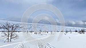 Panorama of harsh northern nature. A group of skiers on a walk. Long shot. Beautiful winter landscape