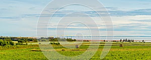 Panorama of hay bales on a farm along the ocean with the Confederation Bridge in the background photo