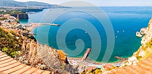 Panorama of high cliffs, Tyrrhenian sea bay with pure azure water, floating boats and ships, pebble beaches, rocky surroundings of