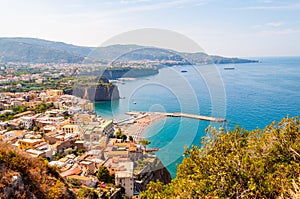 Panorama of high cliffs, Tyrrhenian sea bay with pure azure water, floating boats and ships, pebble beaches, rocky surroundings of