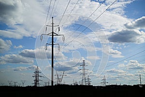 Panorama of high voltage substation. Distribution electrical power. Silhouettes of pylons and towers