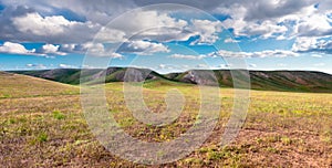 Panorama hills in sunny day. Vista scenic idylic landscape hills sun through the clouds meadow