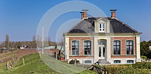 Panorama of a historic house behind the dike in Zoutkamp