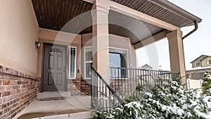 Panorama Home with bay window sidelight and glass paned wooden door against cloudy sky