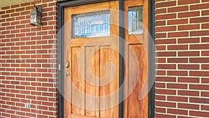 Panorama Home with brick and wood wall sections and glass paned front door and sidelight