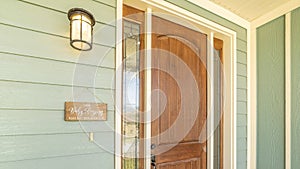 Panorama A home with brown front door sidelight green wood all and stone brick wall