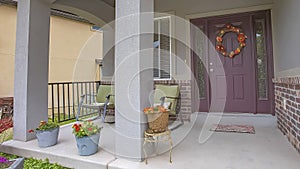 Panorama Home facade with rocking chairs and potted flowers on the concrete porch