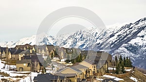 Panorama Homes along a paved mountain road against bright cloudy sky in winter