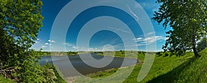 panorama, horizontal view of bay. Great blue lake and green field