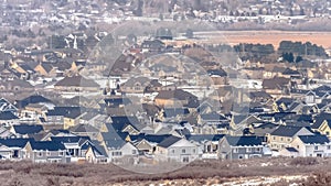 Panorama Houses in Alpine Utah neighborhood amid snowy hill and abundant trees in winter photo