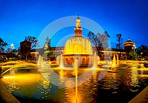 Panorama of the illuminated fountain before facade of Sforza\'s Castle in Milan, Italy