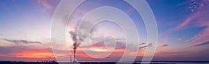 Panorama of an industrial landscape. Thermal power plant on a background of red sunset, aerial view