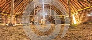 Panorama interior of old farm barn with straw