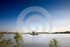 Panorama of an isolated and remote island on a lake in Ribnjak Sakule pond at dusk in Summer. Sakule is a Serbian village of Banat