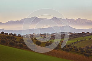 Panorama of the Italian countryside with misty and snowy mountains