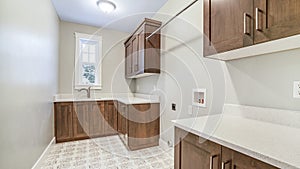 Panorama Kitchen interior with brown wooen cabinets white countertops sink and window