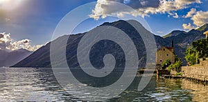 Old stone house in Kotor Bay with mountains and crystal clear water in the Balkans, Montenegro on the on Adriatic Sea