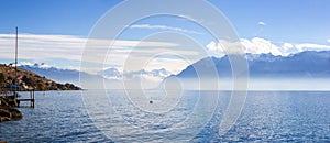 Panorama of Lake Leman or Lake of Geneva with morning mist over the water surface