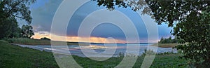 Panorama of a lake near Berlin in the evening with rainy clouds traversing in the background