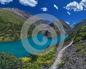 Panorama landscape with blue lake in mountains in summer. Koksai Ainakol Lake in Tien Shan Mountains in Asia in