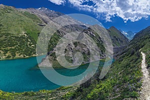 Panorama landscape with blue lake in mountains in summer. Koksai Ainakol Lake in Tien Shan Mountains in Asia in