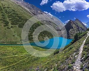 Panorama landscape with blue lake in mountains in summer. Koksai Ainakol Lake in Tien Shan Mountains in Asia in